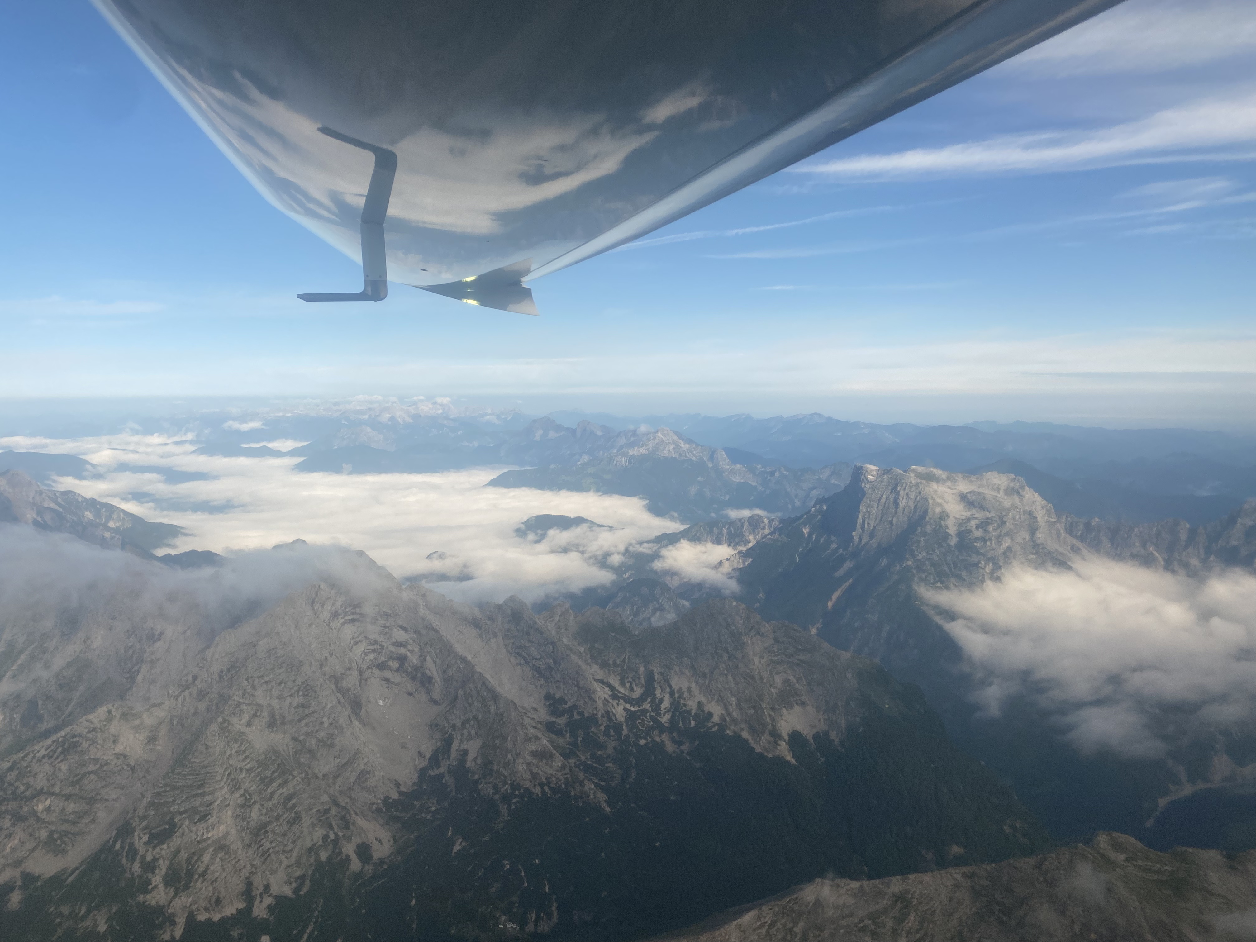 Reiseblick über eine Berglandschaft unter dem Flügel